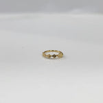 Top view of a petite 18K gold nose ring placed flat on a clean white surface