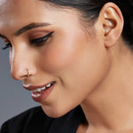 Smiling woman wearing a delicate gold nose ring styled for a modern minimal look