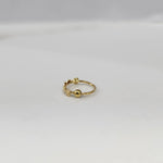 Side angle view of delicate zigzag gold nose ring on a white background showing the opening and fit