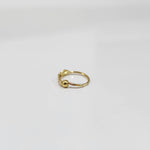 Side angle view of petite zigzag motif gold nose ring on a white surface showing the clasp and lightweight structure