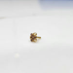 Slight angled view of the stone nose pin on a white surface emphasizing the raised stone arrangement