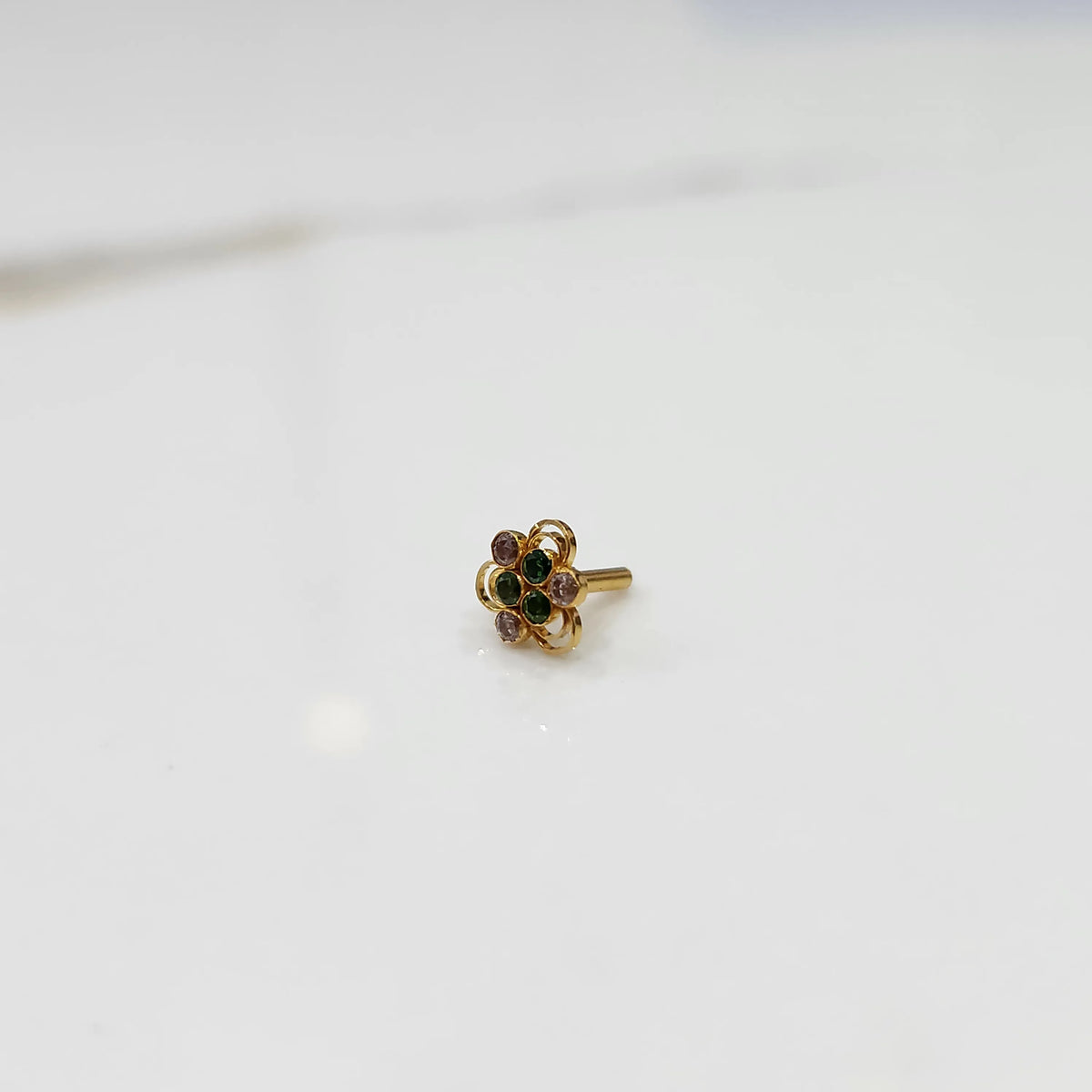 Distant view of the stone gold nose pin on a white background showing its petite everyday size