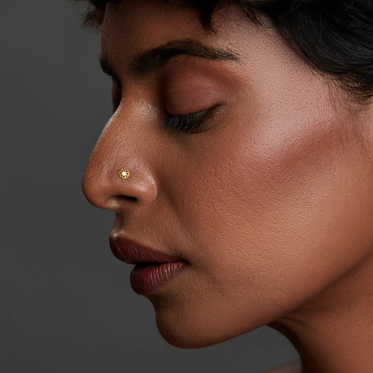 Side profile of a woman wearing a minimal gold nose pin showcasing an elegant everyday look
