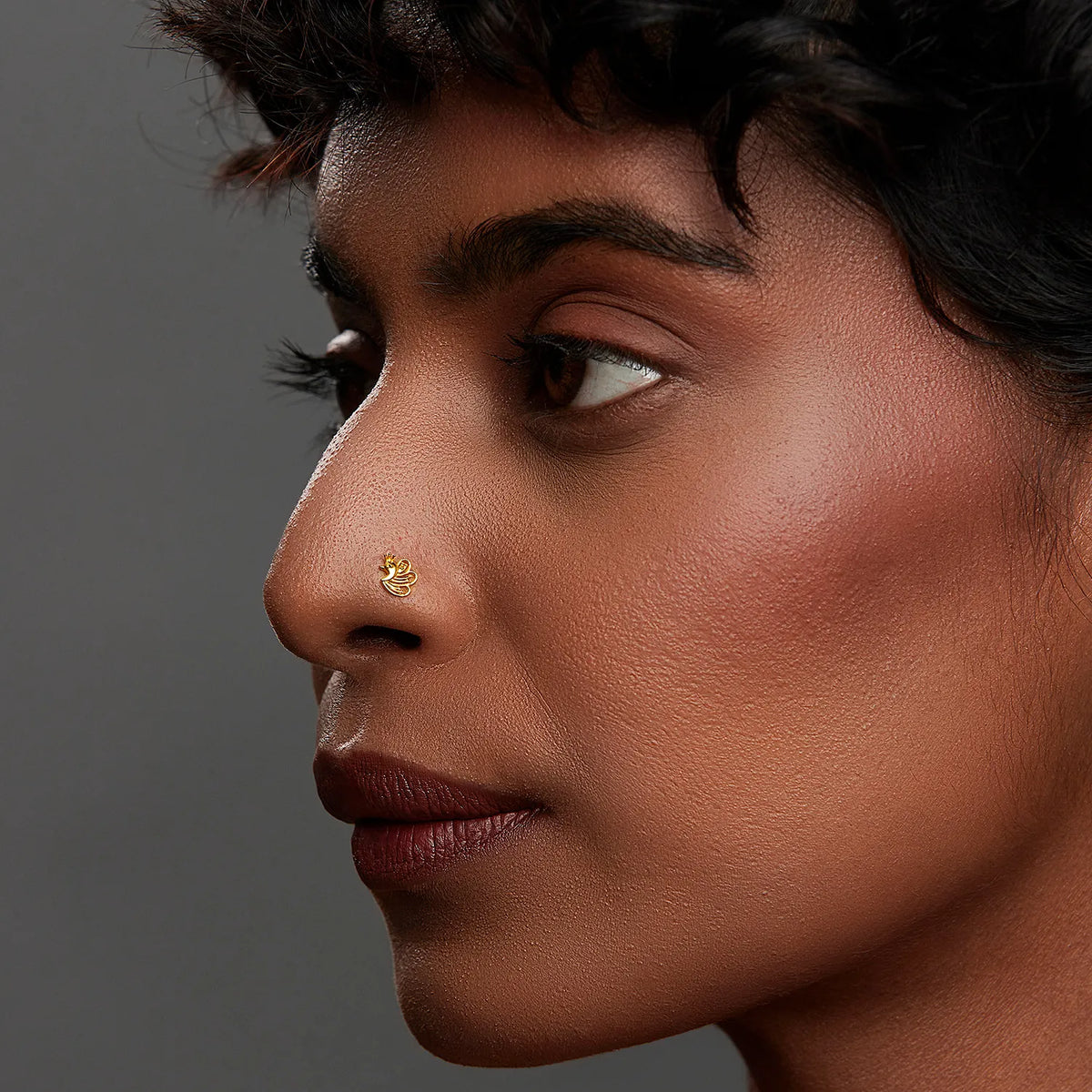 Woman wearing a minimalist 18K nose pin gold showcasing a refined everyday look in a side profile close up