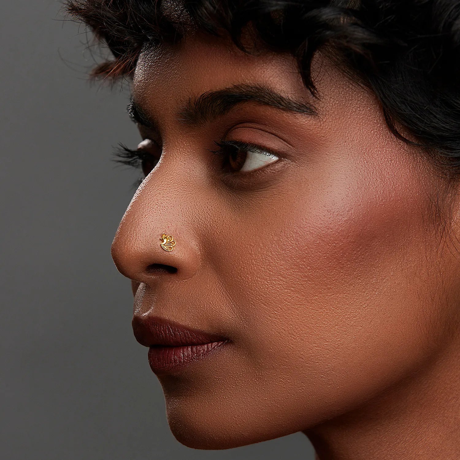 Woman wearing a minimalist 18K nose pin gold showcasing a refined everyday look in a side profile close up