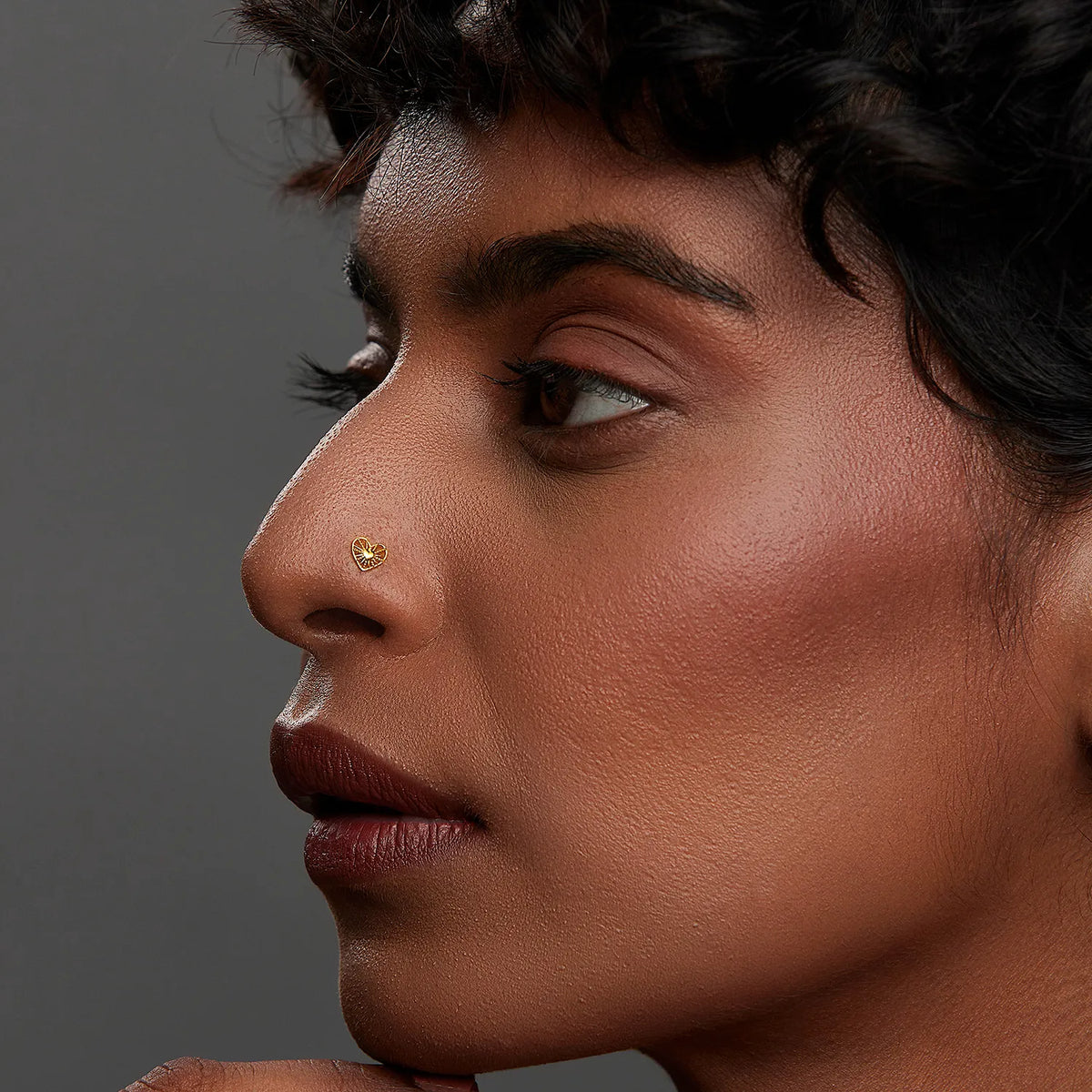 Woman wearing a minimalist 18K nose pin gold in side profile highlighting a clean elegant everyday look