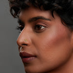 Woman wearing a heart motif gold nose pin showcasing a subtle elegant everyday look