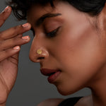 Woman wearing a textured 18K gold nose pin showcasing an elegant and minimal aesthetic