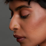 Woman wearing a swastik motif 18K nose pin gold showcasing a traditional yet minimalist ethnic look