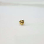 Front view of a small gold nose pin on a white background showcasing fine detailing and compact size