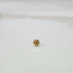 Front view of a small floral gold nose pin placed on a clean white background showing its delicate design and compact size
