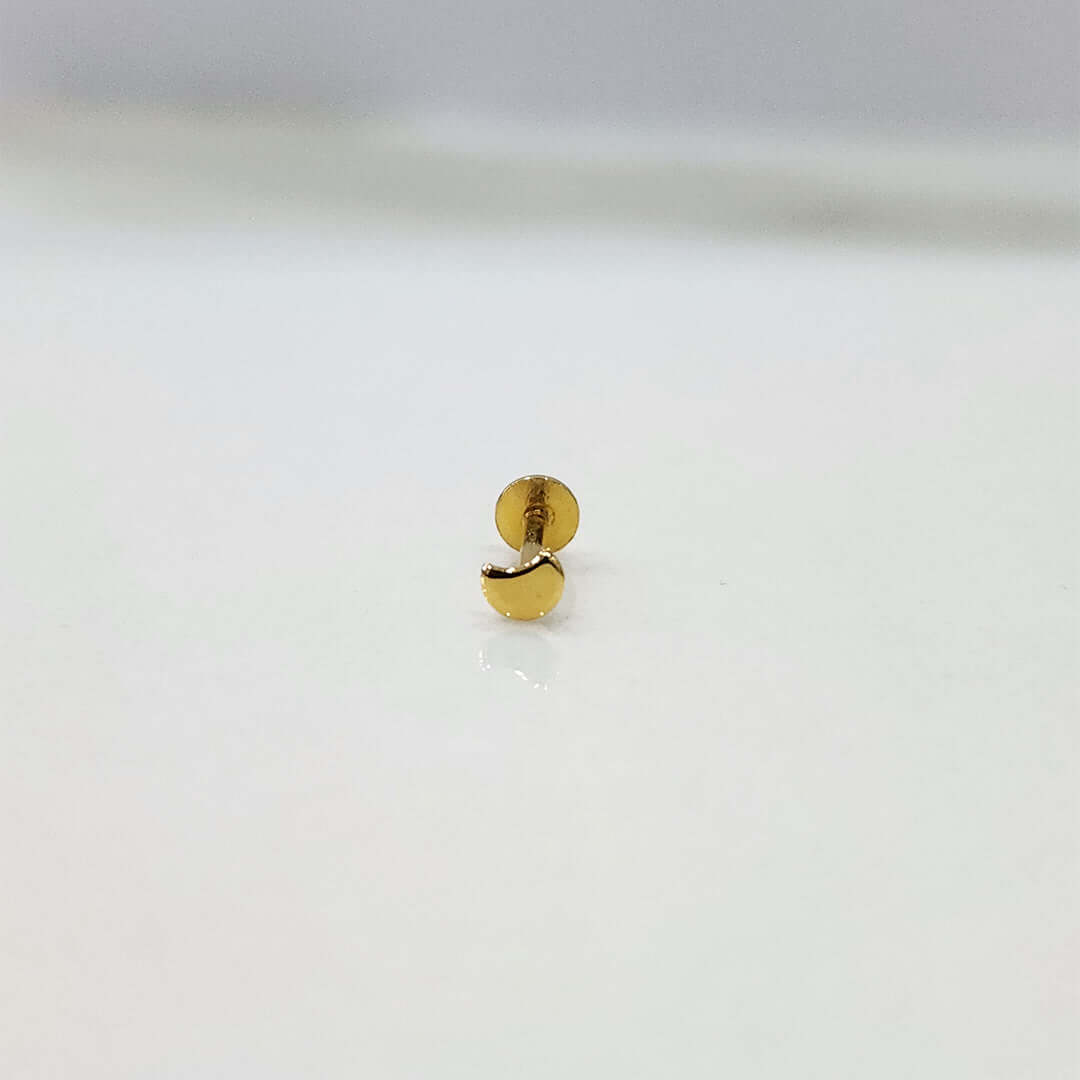 Small crescent 18K nose pin gold placed on a white background showing delicate detailing