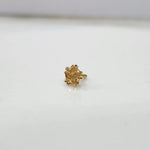 Front view of a tiny floral 18K nose pin gold placed on a white surface highlighting its compact design