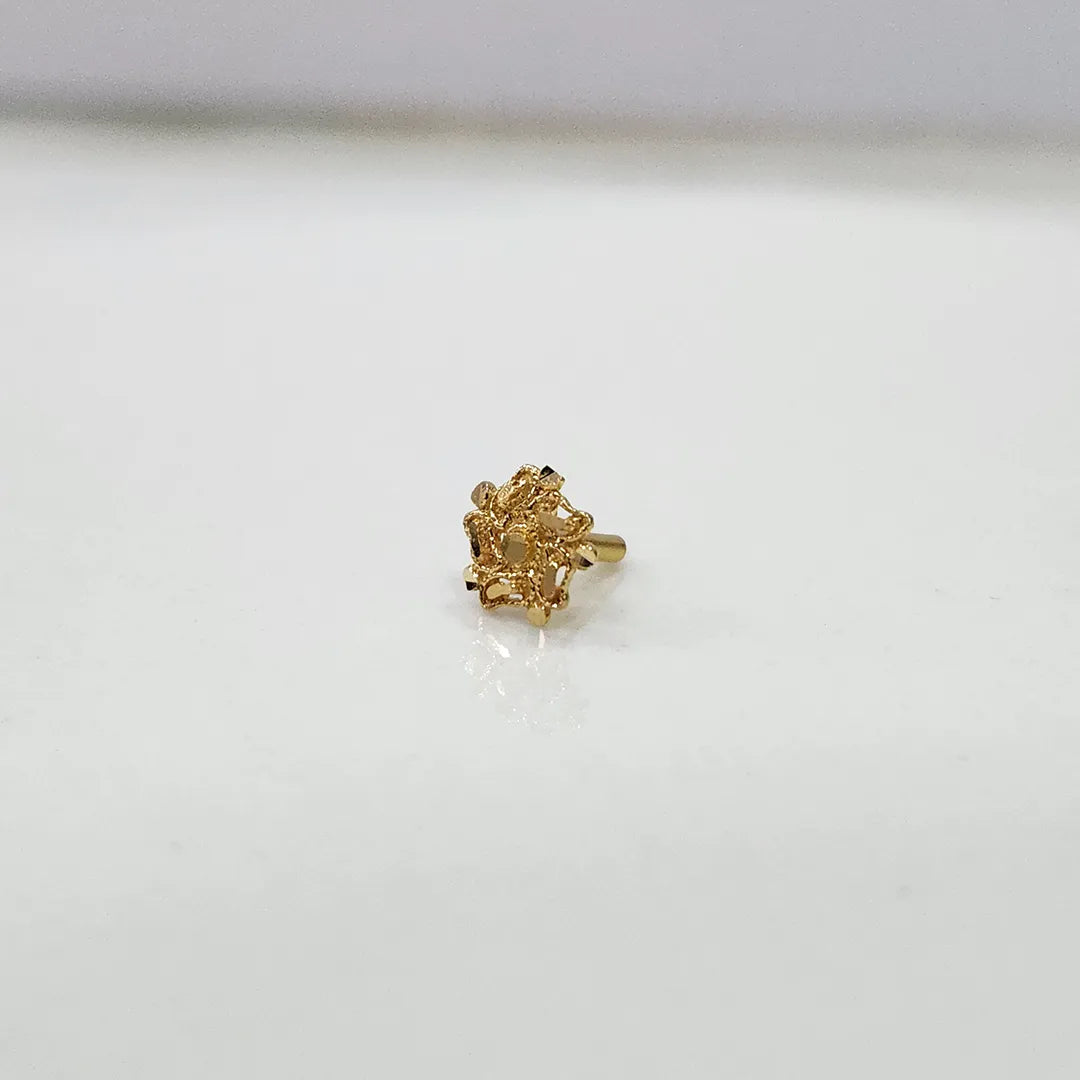Front view of a tiny floral 18K nose pin gold placed on a white surface highlighting its compact design
