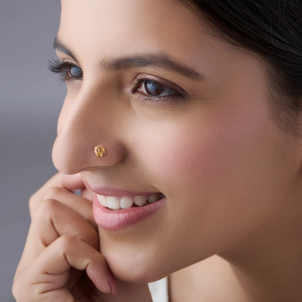 Woman wearing a delicate 18K nose pin gold showcasing an elegant everyday and festive look