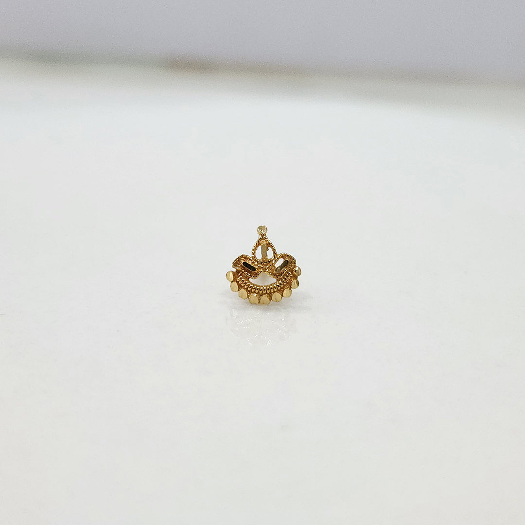 Close up of crescent shaped gold nose pin design on white background highlighting fine texture