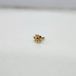 Close up of a small floral 18K nose pin gold placed on a white background showing fine craftsmanship and compact size