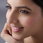 Woman wearing a delicate 18K nose pin gold showcasing an elegant everyday look in a soft portrait profile