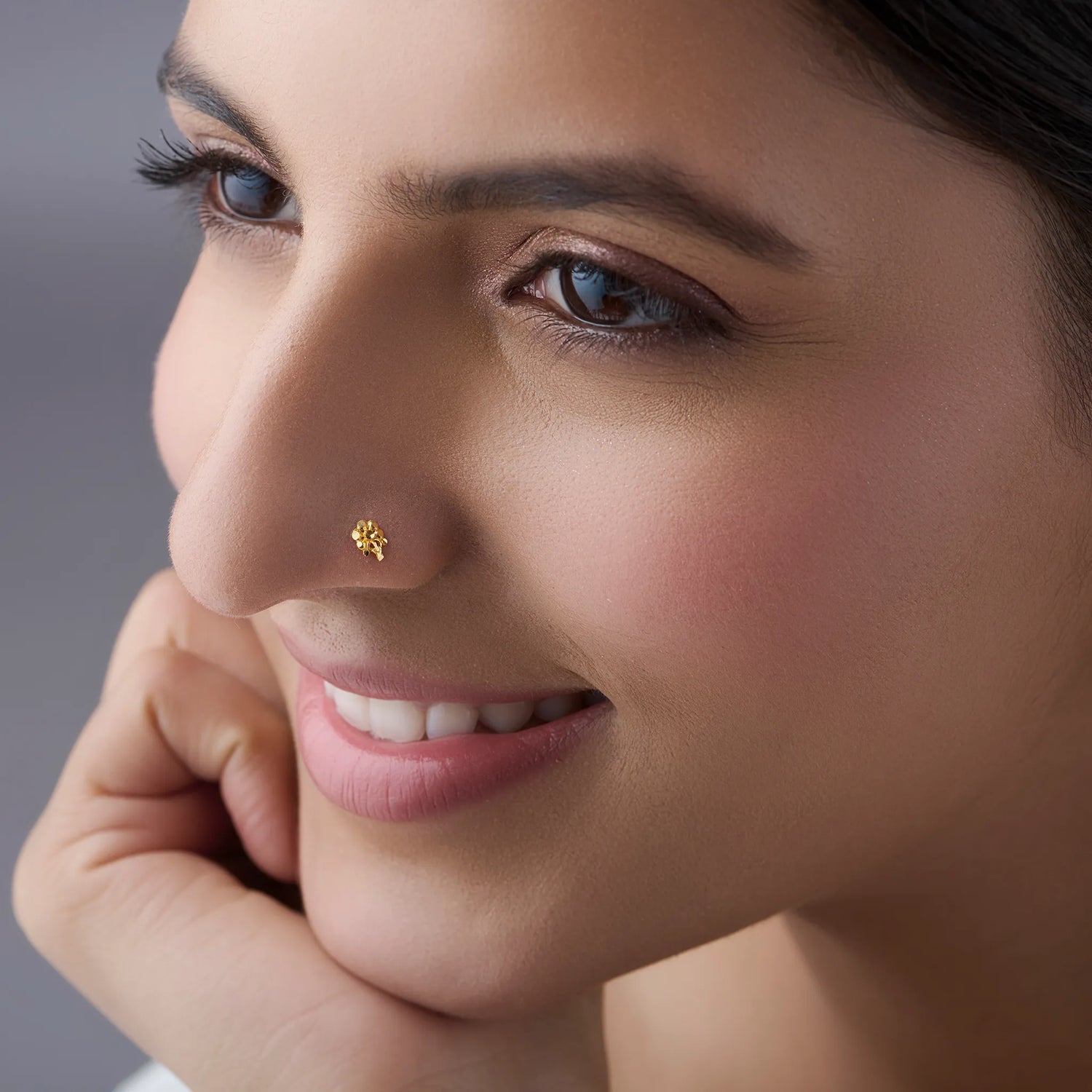 Woman wearing a delicate 18K nose pin gold showcasing an elegant everyday look in a soft portrait profile