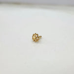 Slight angle view of floral motif 18K gold nose pin on a white background highlighting depth and finish