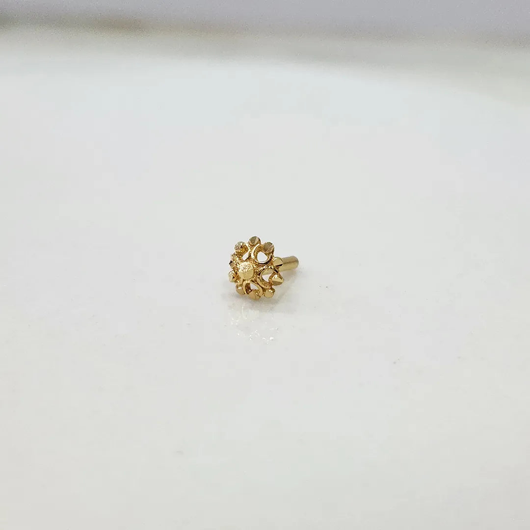 Slight angle view of floral motif 18K gold nose pin on a white background highlighting depth and finish