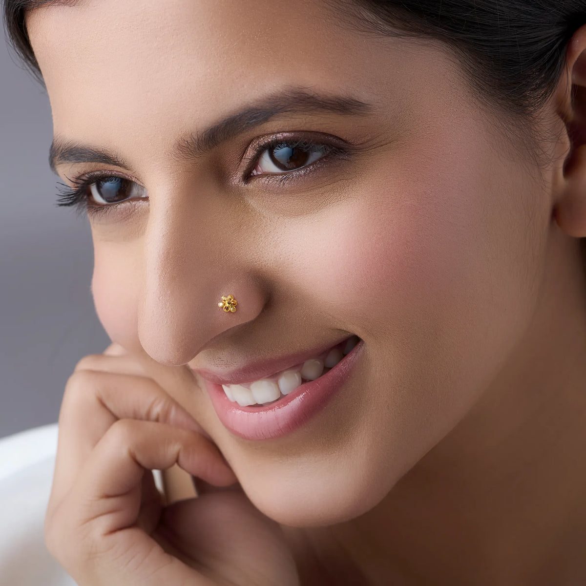 Woman wearing a floral 18K nose pin gold showcasing a graceful everyday look with a soft elegant expression