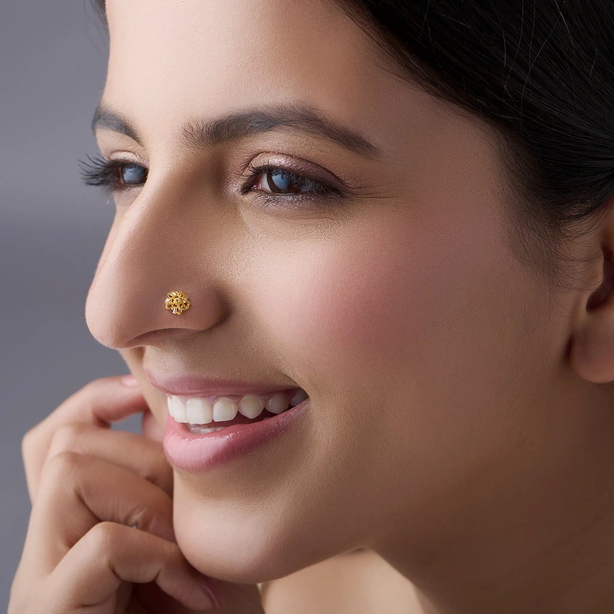 Woman wearing a delicate 18K gold floral nose pin showcasing an elegant everyday look