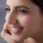 Woman wearing delicate gold nose pin design showcasing triangular motif and classic indian jewellery style