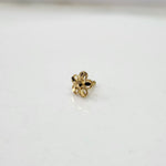 Front view close up of a small 18K nose pin gold on a white background highlighting fine detailing