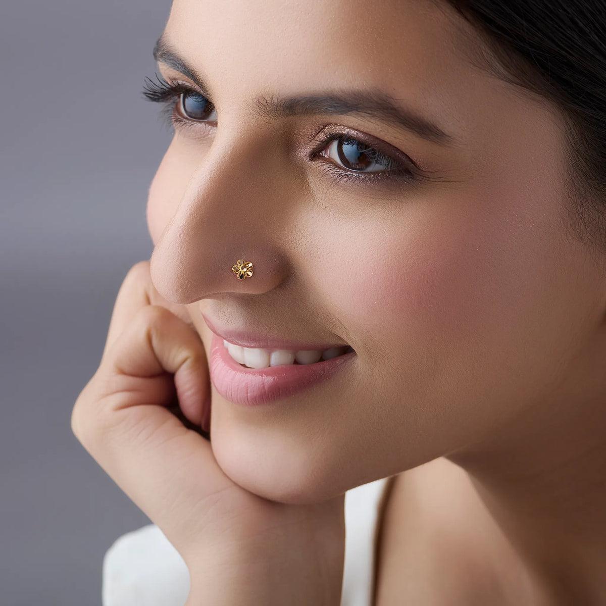 Woman wearing a delicate 18K nose pin gold showcasing an elegant everyday and festive look