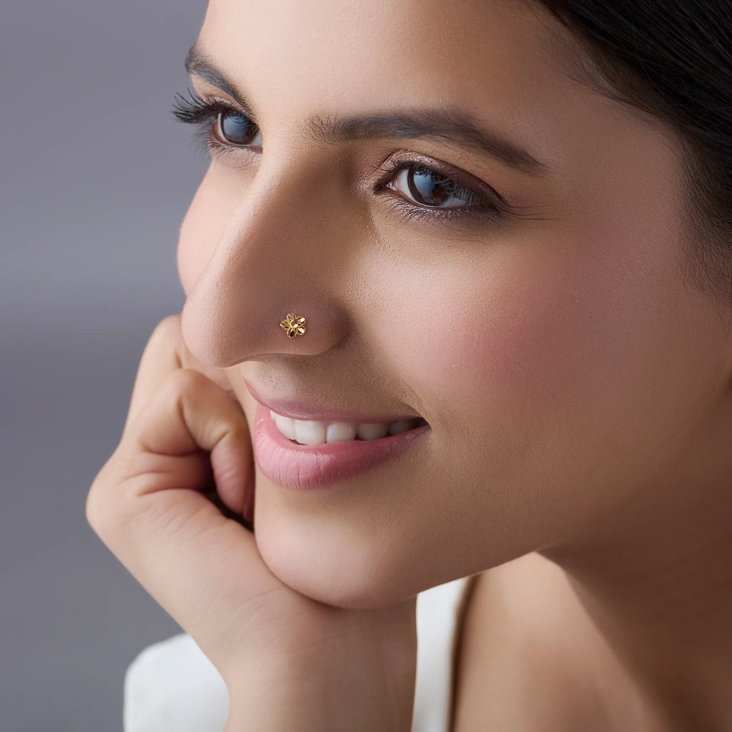 Woman wearing a delicate 18K nose pin gold showcasing an elegant everyday and festive look