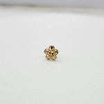 Side view of a compact 18K nose pin gold placed on a white surface showing subtle shine and smooth edges