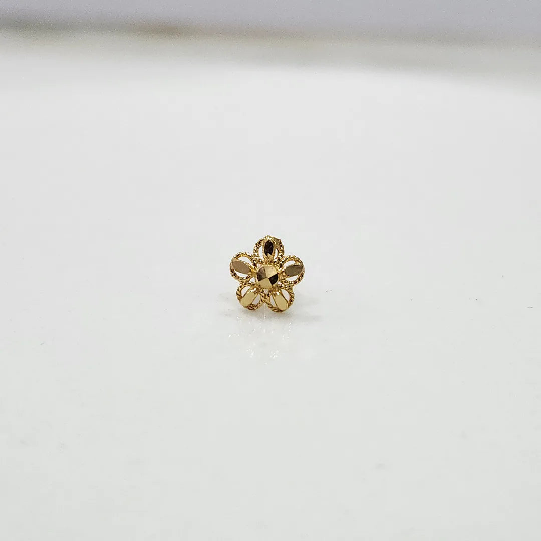 Side view of a compact 18K nose pin gold placed on a white surface showing subtle shine and smooth edges