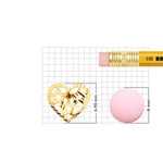 Gold nose pin displayed beside pencil for size comparison highlighting intricate handcrafted design