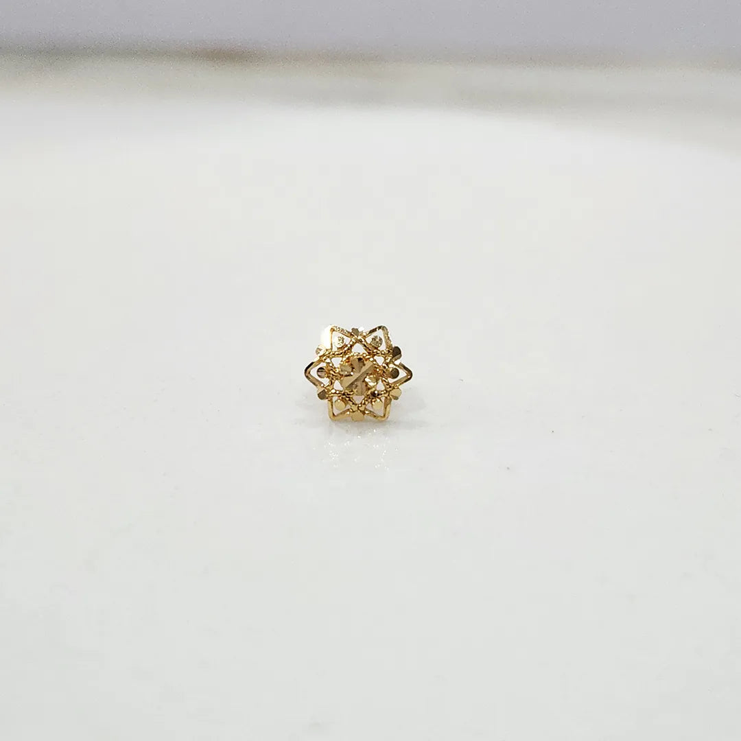 Front view of a small floral 18K nose pin gold placed on a white background highlighting its compact and delicate design