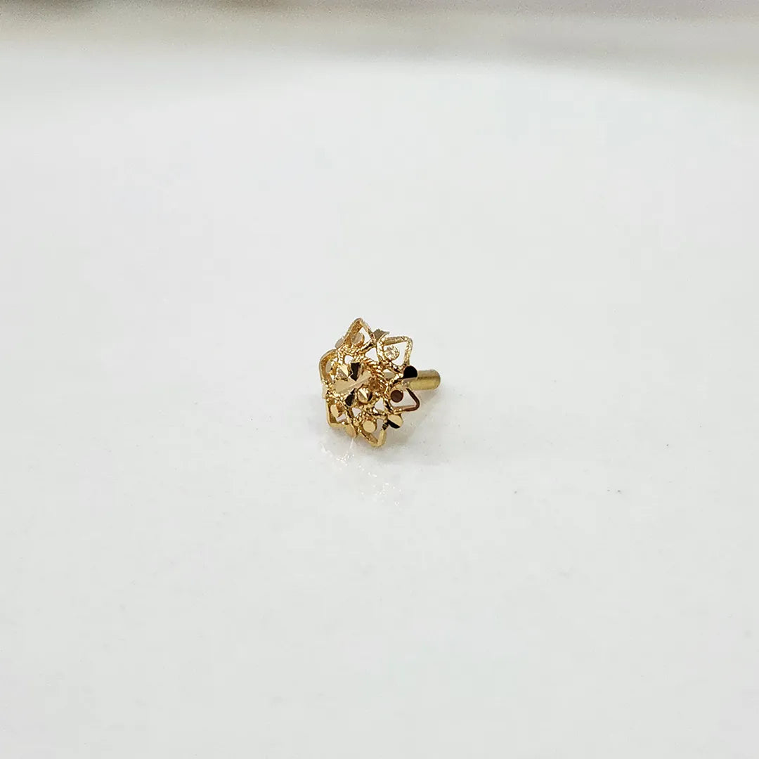 Side view of a floral 18K nose pin gold on a white surface showing fine detailing and polished finish