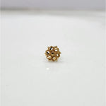 Front view of a small 18K nose pin gold placed on a white background showing detailed floral pattern