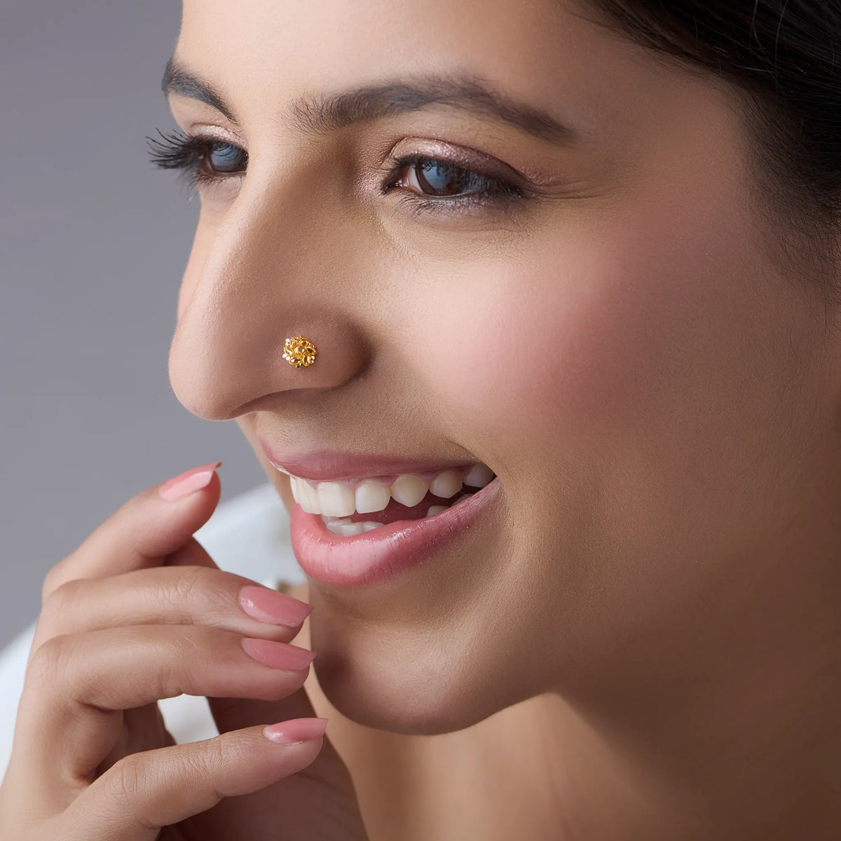 Smiling woman wearing a minimalist 18K nose pin gold highlighting subtle shine and lightweight comfort