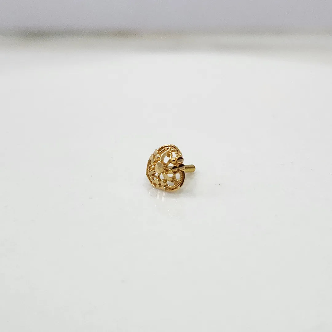 Side view of a tiny 18K nose pin gold placed on a white surface highlighting its polished finish and fine craftsmanship