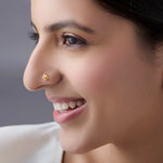 Woman smiling while wearing a delicate 18K nose pin gold showcasing an elegant and graceful everyday look