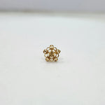 Side view of a tiny floral 18K nose pin gold on a white surface highlighting its compact size and polished finish