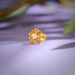 Close-up of floral 18K nose pin gold placed on a soft lavender surface highlighting its intricate handcrafted design