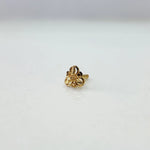 Front view of a tiny floral 18K gold nose pin on a white background showing its delicate detailing