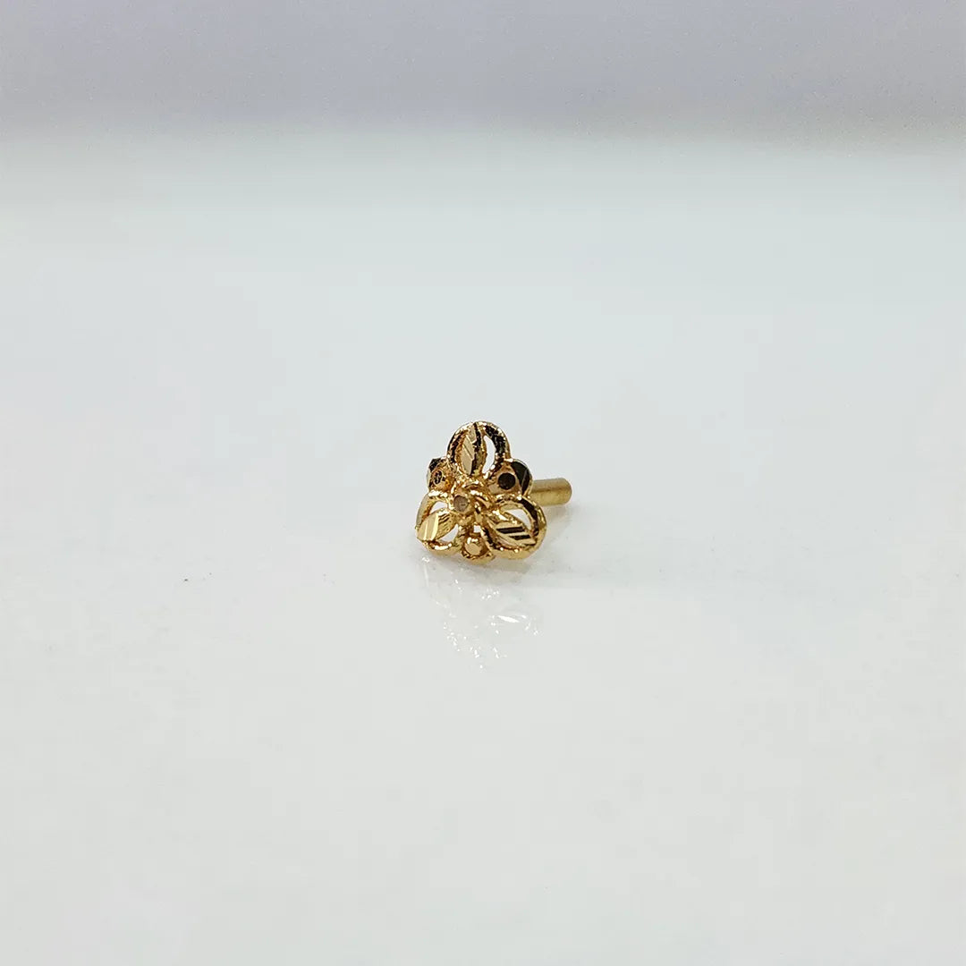 Front view of a tiny floral 18K gold nose pin on a white background showing its delicate detailing