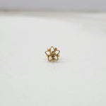 Small floral 18K gold nose pin on a white background displaying its fine craftsmanship