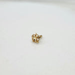 Side view of a tiny 18K gold floral nose pin on a white background showing fine detailing