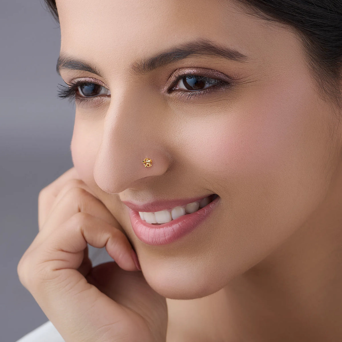 Woman wearing a delicate 18K gold floral nose pin highlighting its elegant everyday appeal