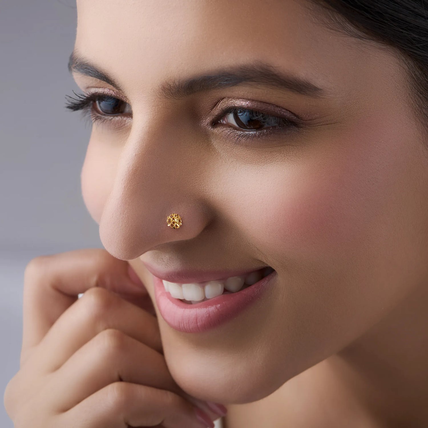 Woman wearing an elegant 18K gold floral nose pin showcasing a graceful everyday look