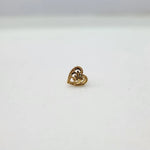 Side view of 18K heart motif gold nose pin placed on a white surface reflecting its polished finish