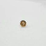 Side view of small 18K floral gold nose pin placed on a white surface displaying its polished finish